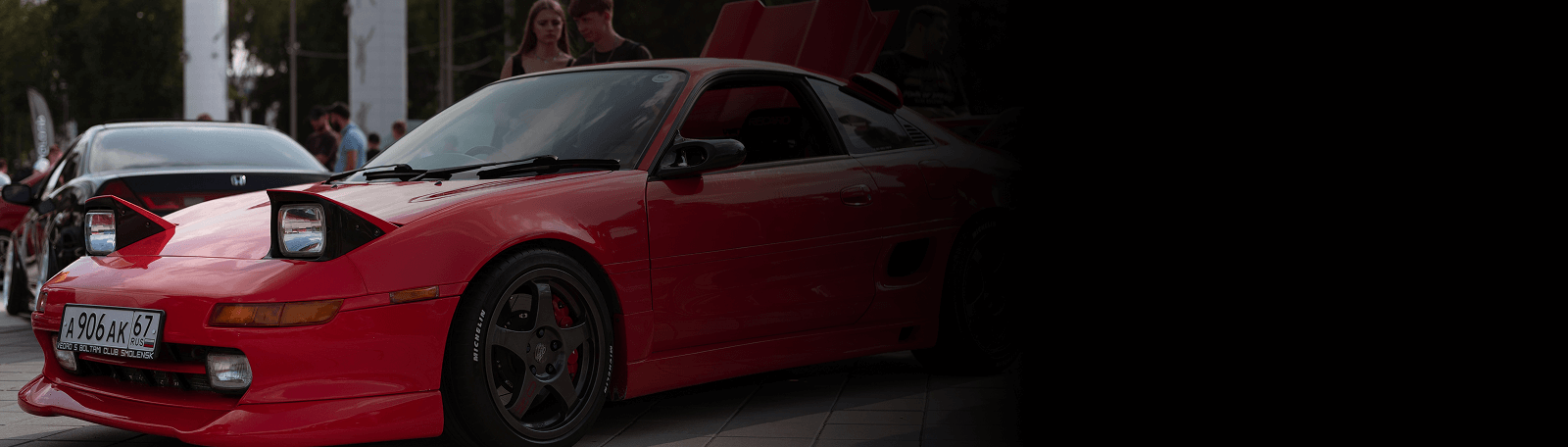 A flashy red Toyota MR2 parked on the street