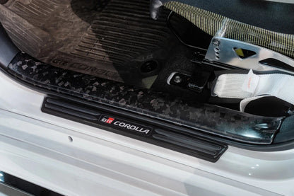 TOM'S Racing [23 - 26 GR Corolla, 19 - 26 Corolla Hatchback] Forged Carbon Front Scuff Plate Cover | TMS - 67913 - TEA14 - JDMuscleTrim KitstmsTMS-67913-TEA14